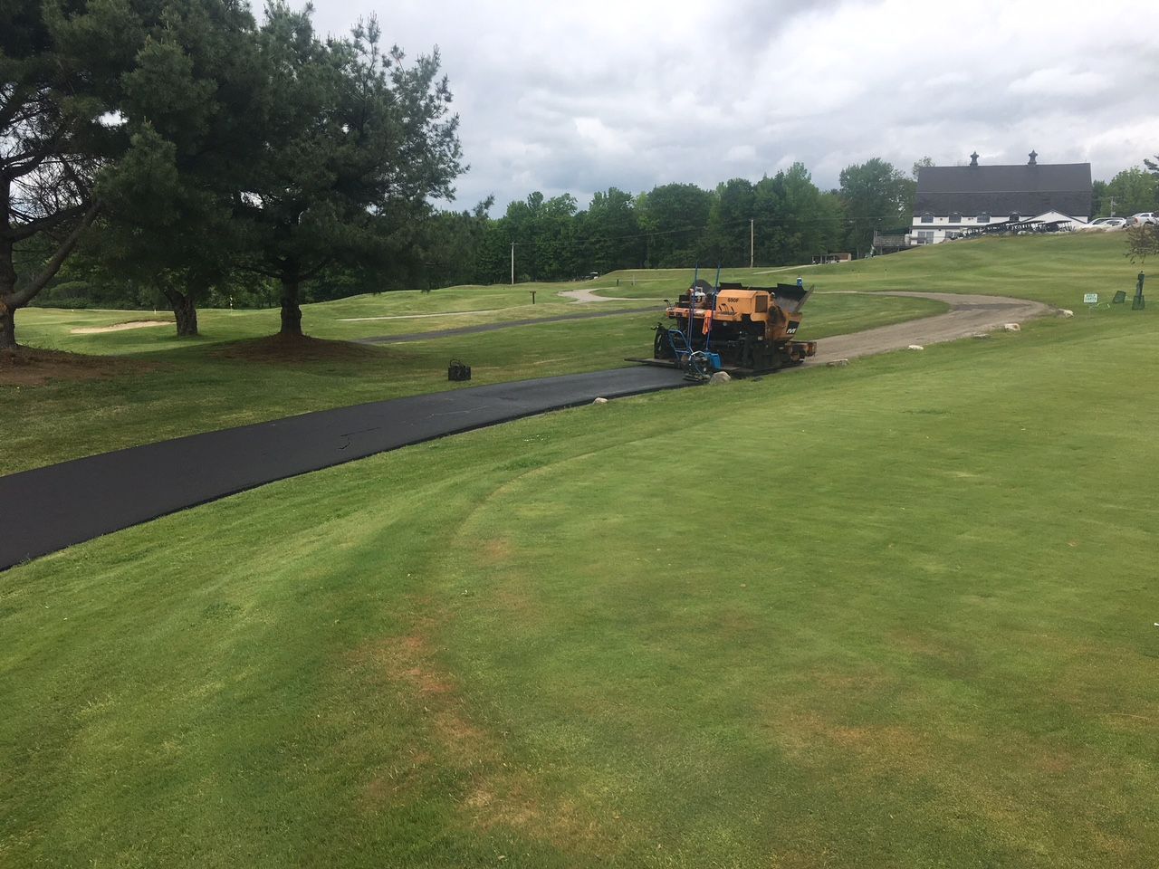 A group of people are working on a golf course.