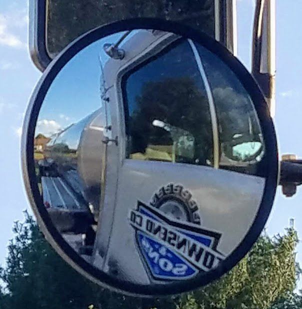A truck is reflected in a side view mirror.