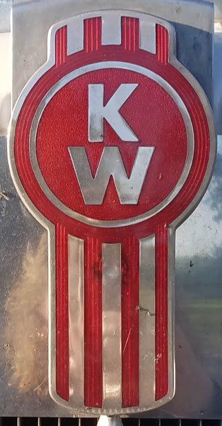 A red and silver kenworth logo on a truck