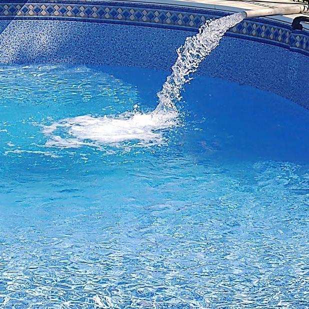 A blue swimming pool with water coming out of it