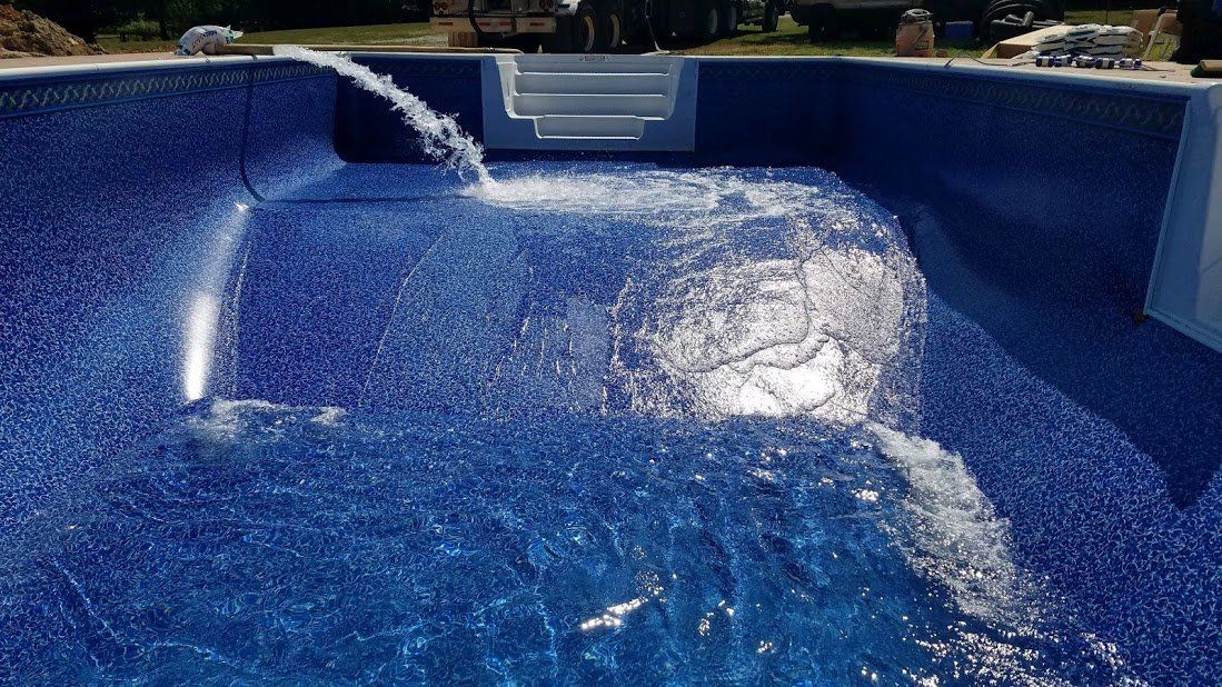 A swimming pool with a fountain in the middle of it.