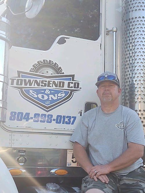 A man is sitting on the back of a truck.