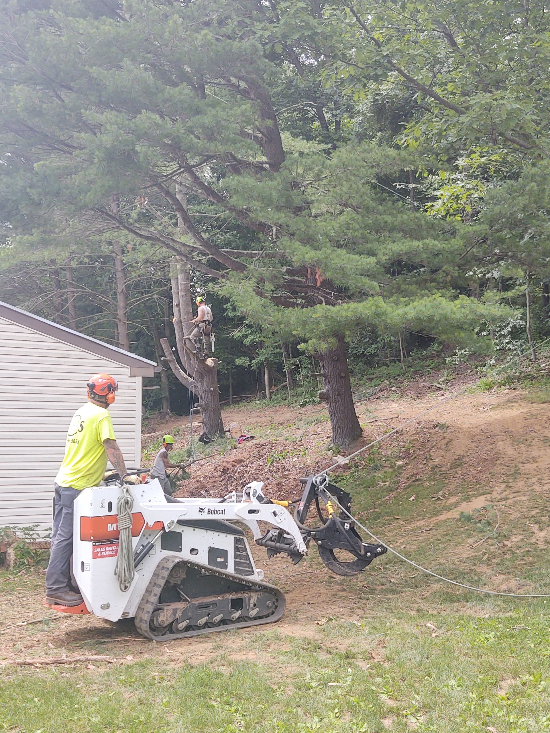 A man is standing next to a bulldozer in a yard.
