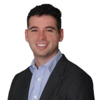 A man and a woman are sitting on a dock overlooking a lake.