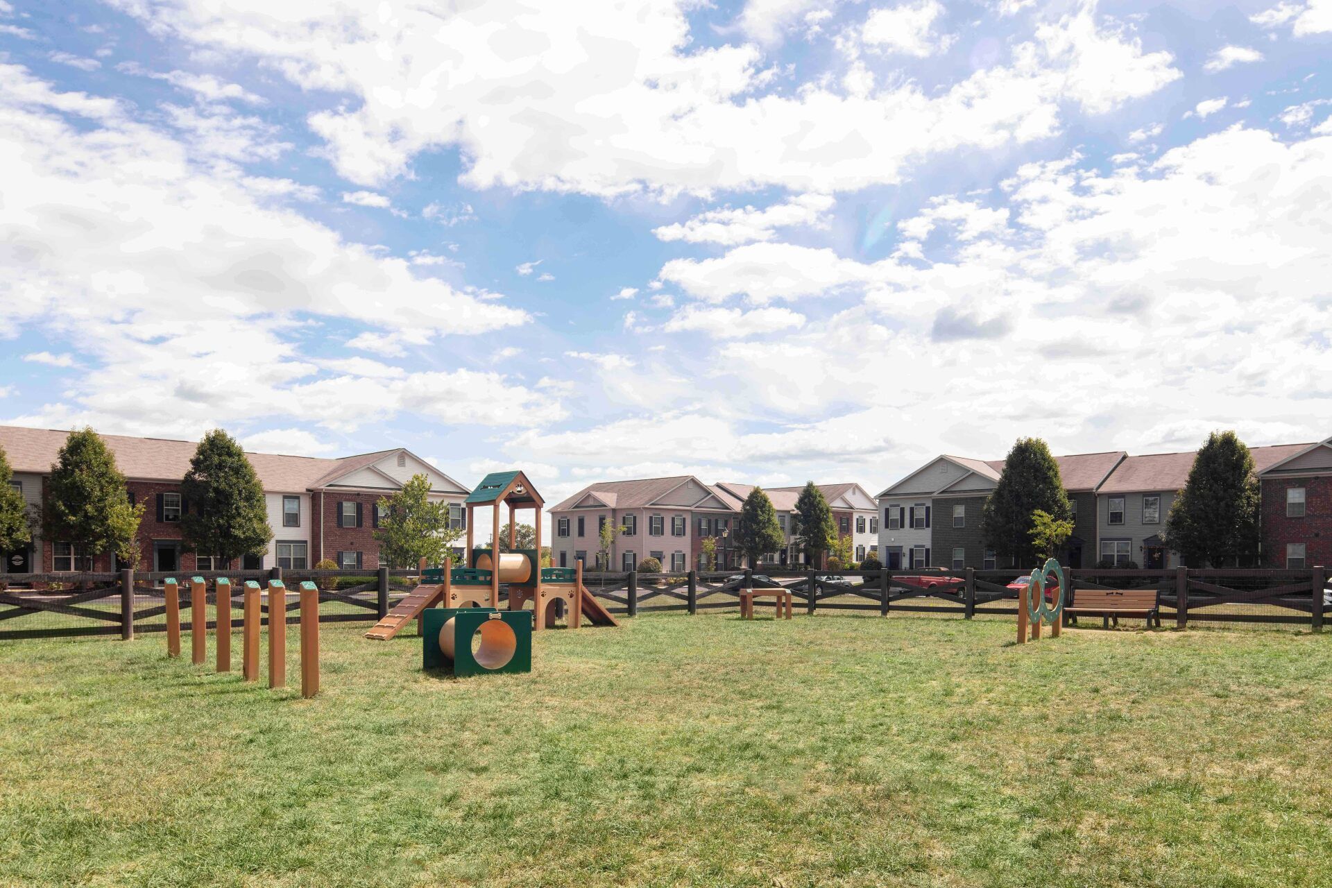 There is a playground in the middle of a grassy field.