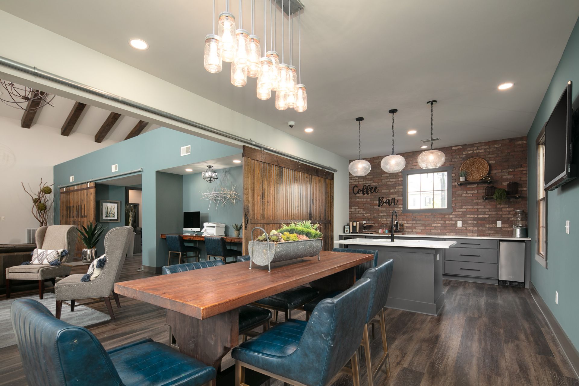 A living room with a dining table and chairs and a kitchen.