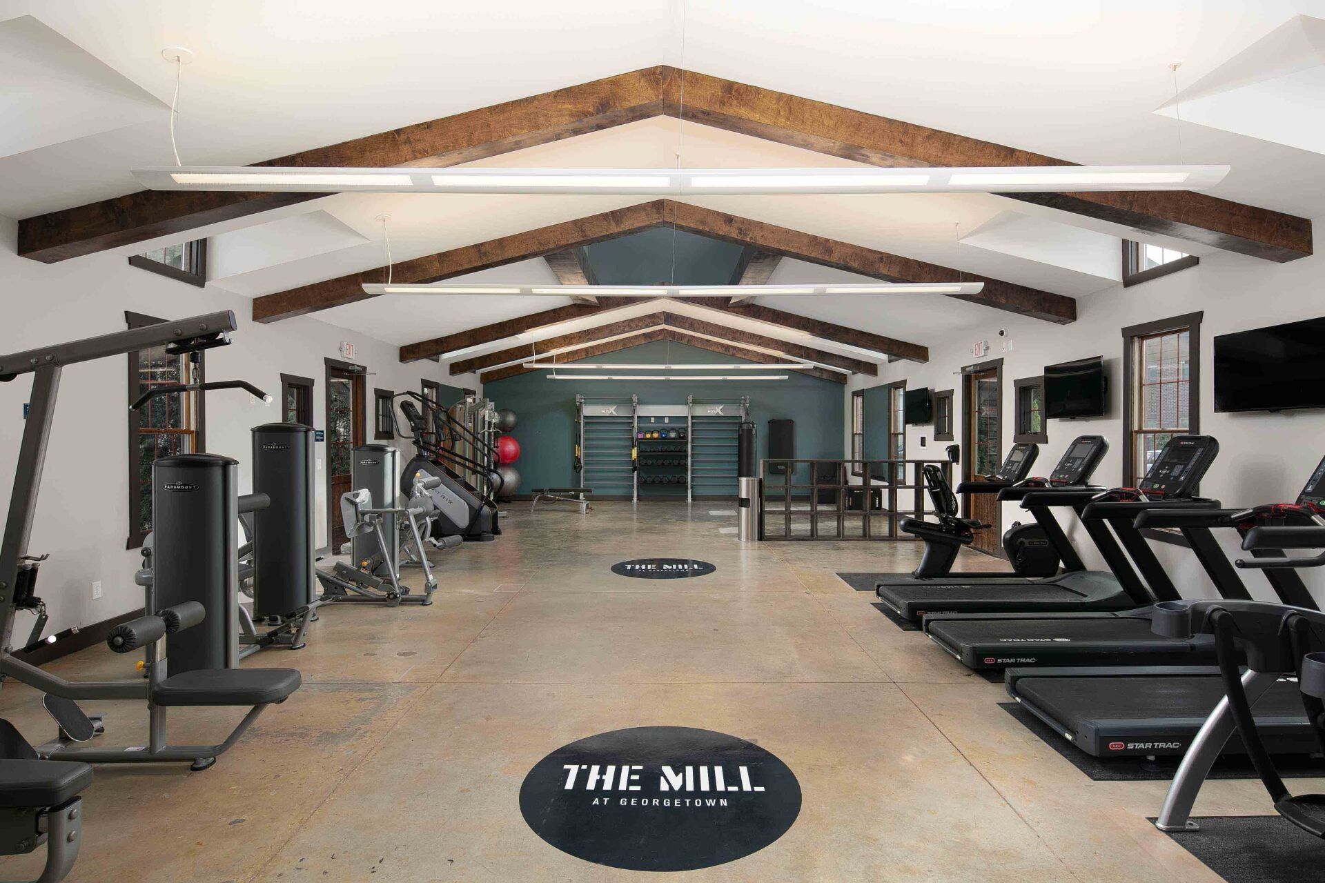A large gym with treadmills and a sign that says the mill