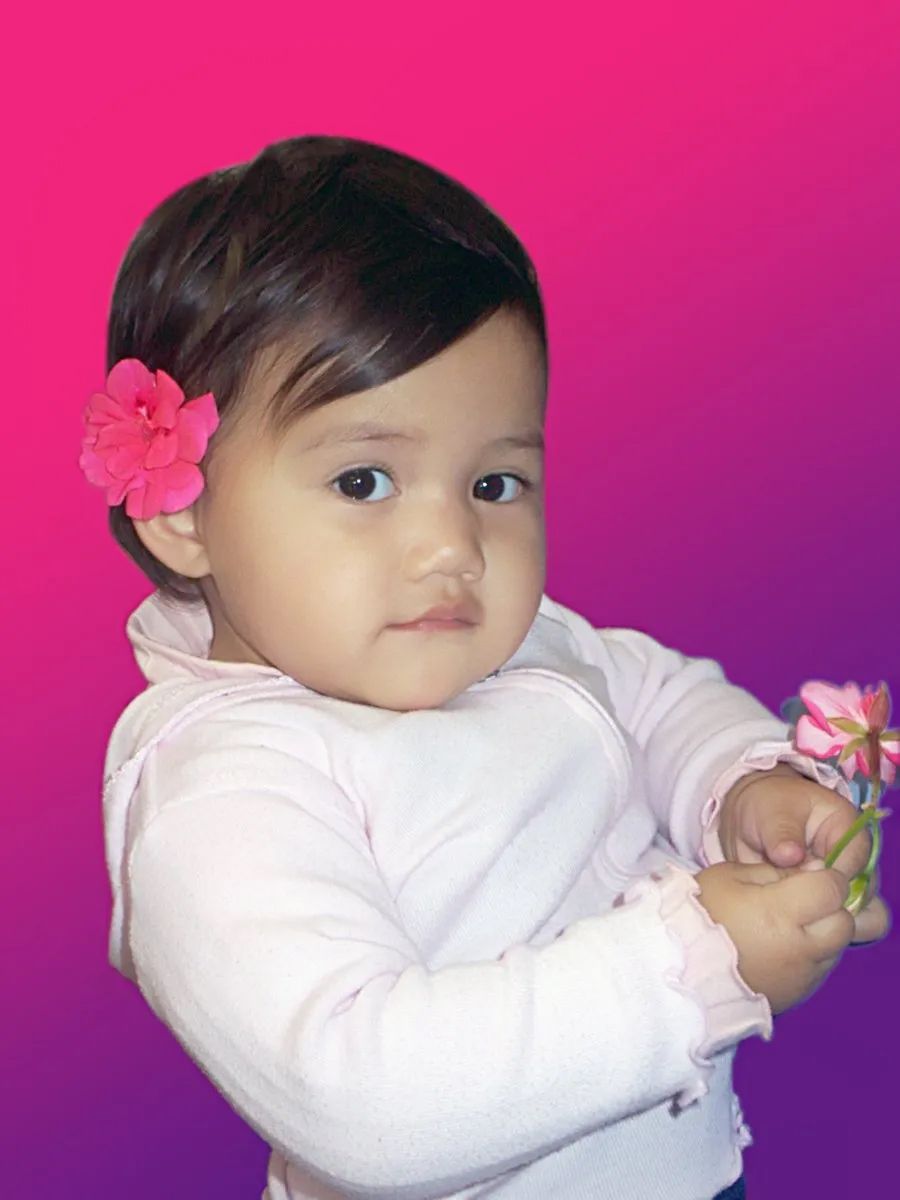 A Child Holding a Small Pink Flower