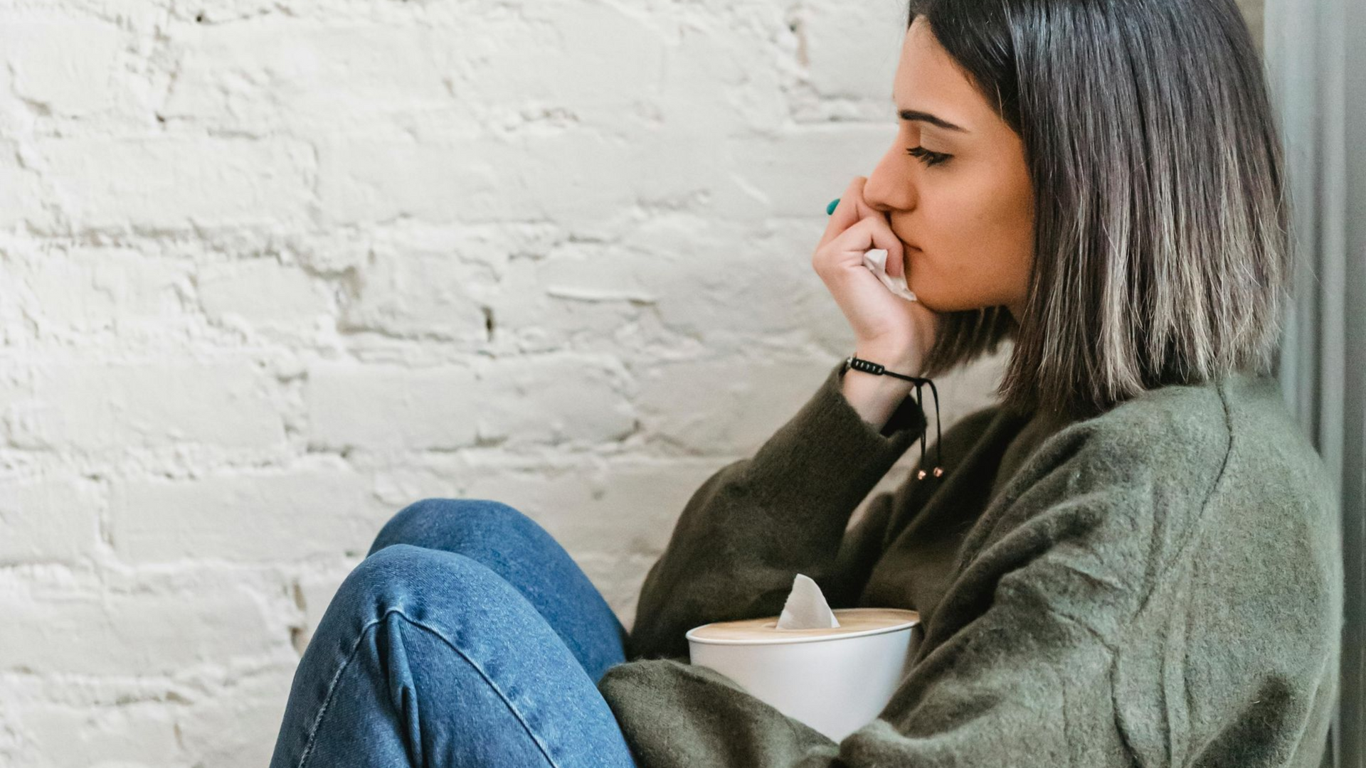 A man is hugging a woman who is crying in front of a mirror.