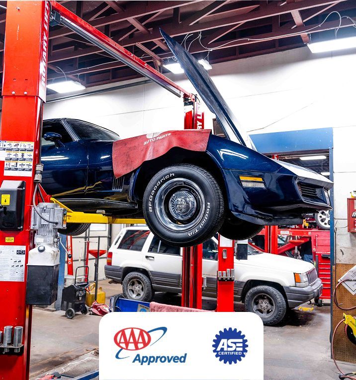 Navy American sports car lifted on a hydraulic jack being worked on | Jerry's Auto Repair