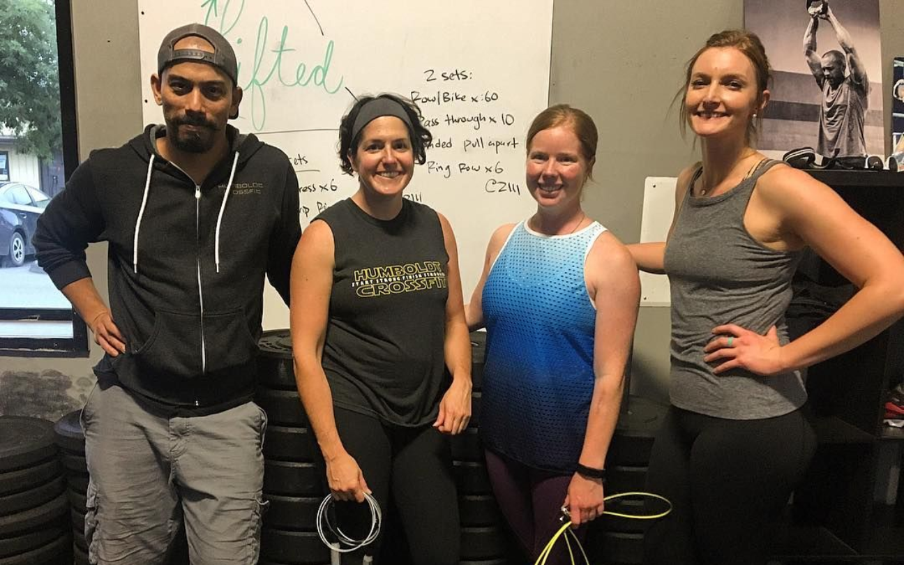 Woman in activewear doing Pilates on reformer machine in a bright studio.