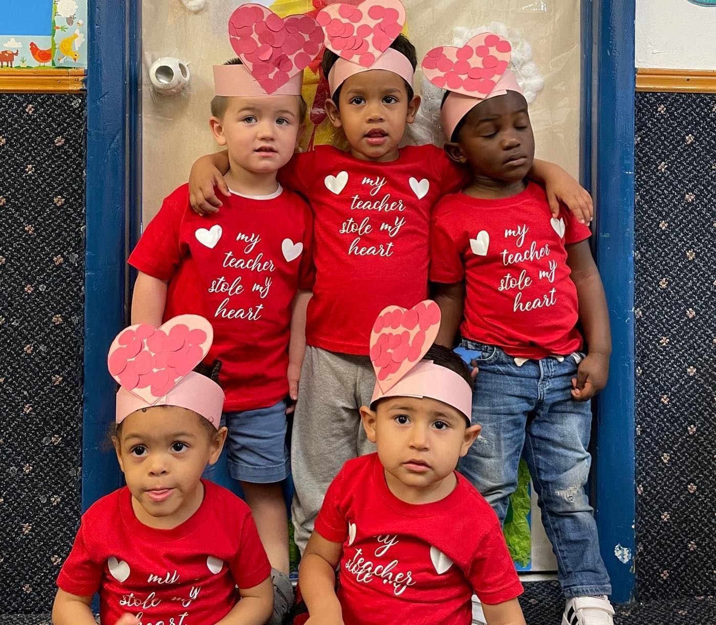 A group of children wearing red shirts with hearts on them