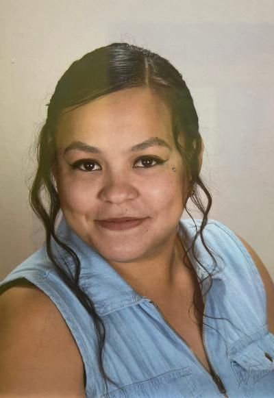 A woman in a blue shirt is smiling for the camera.