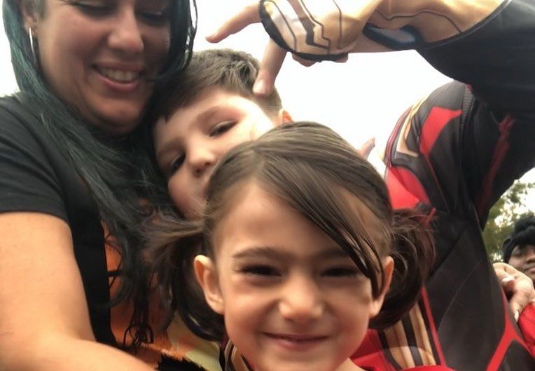 A woman and two children are posing for a picture