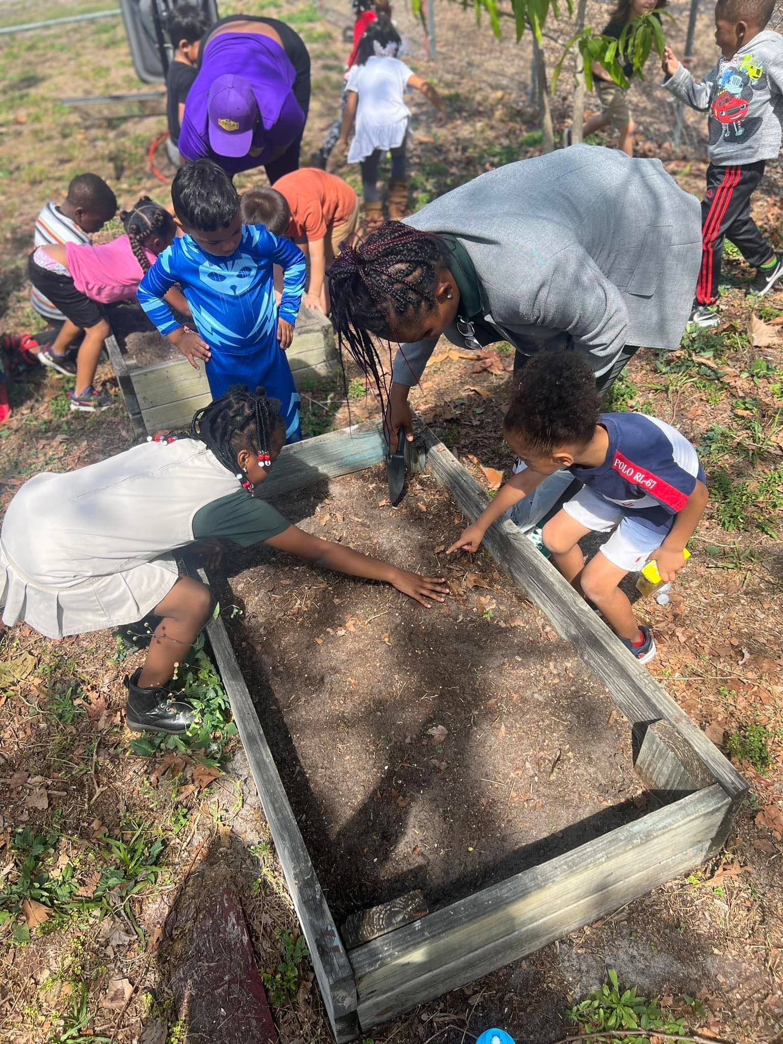 A group of children are working in a garden.