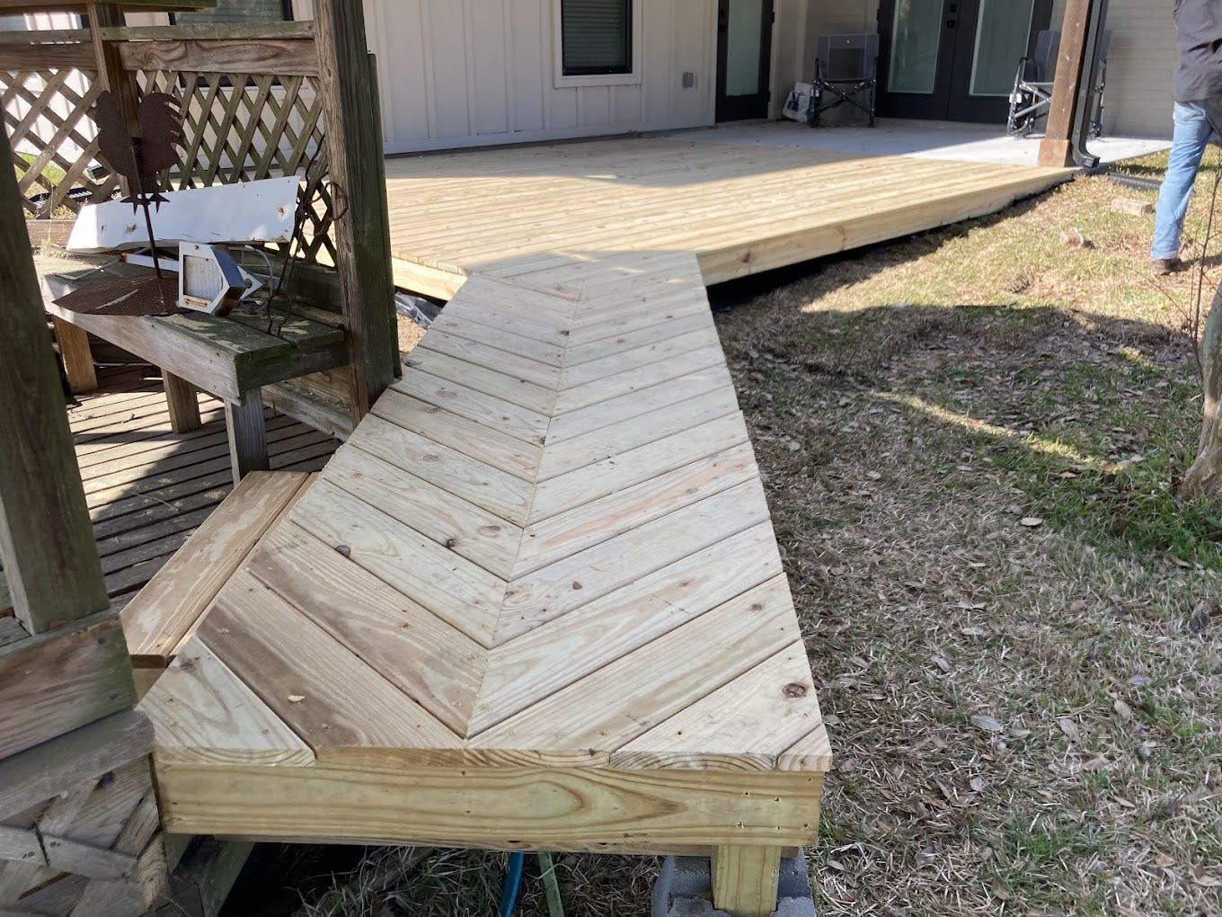 A wooden deck is being built in the backyard of a house.