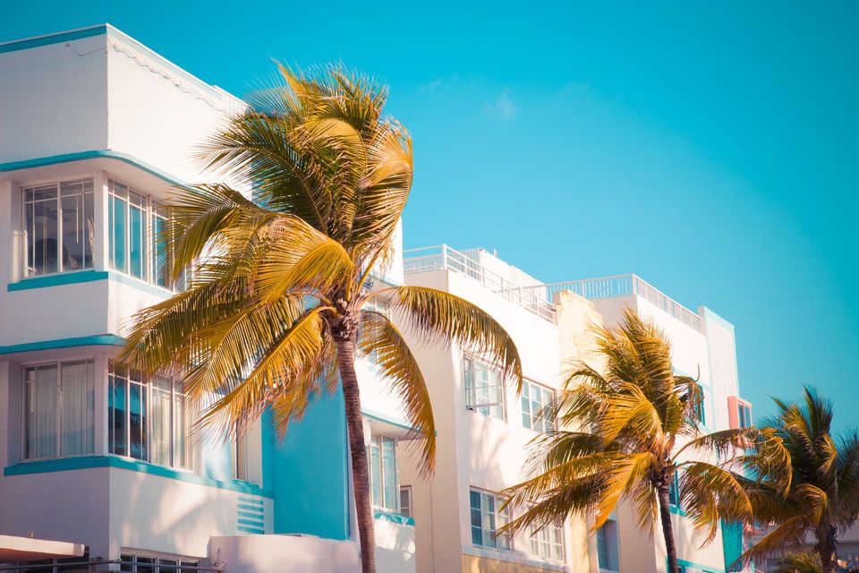 A large apartment building with a lot of windows and balconies against a blue sky.