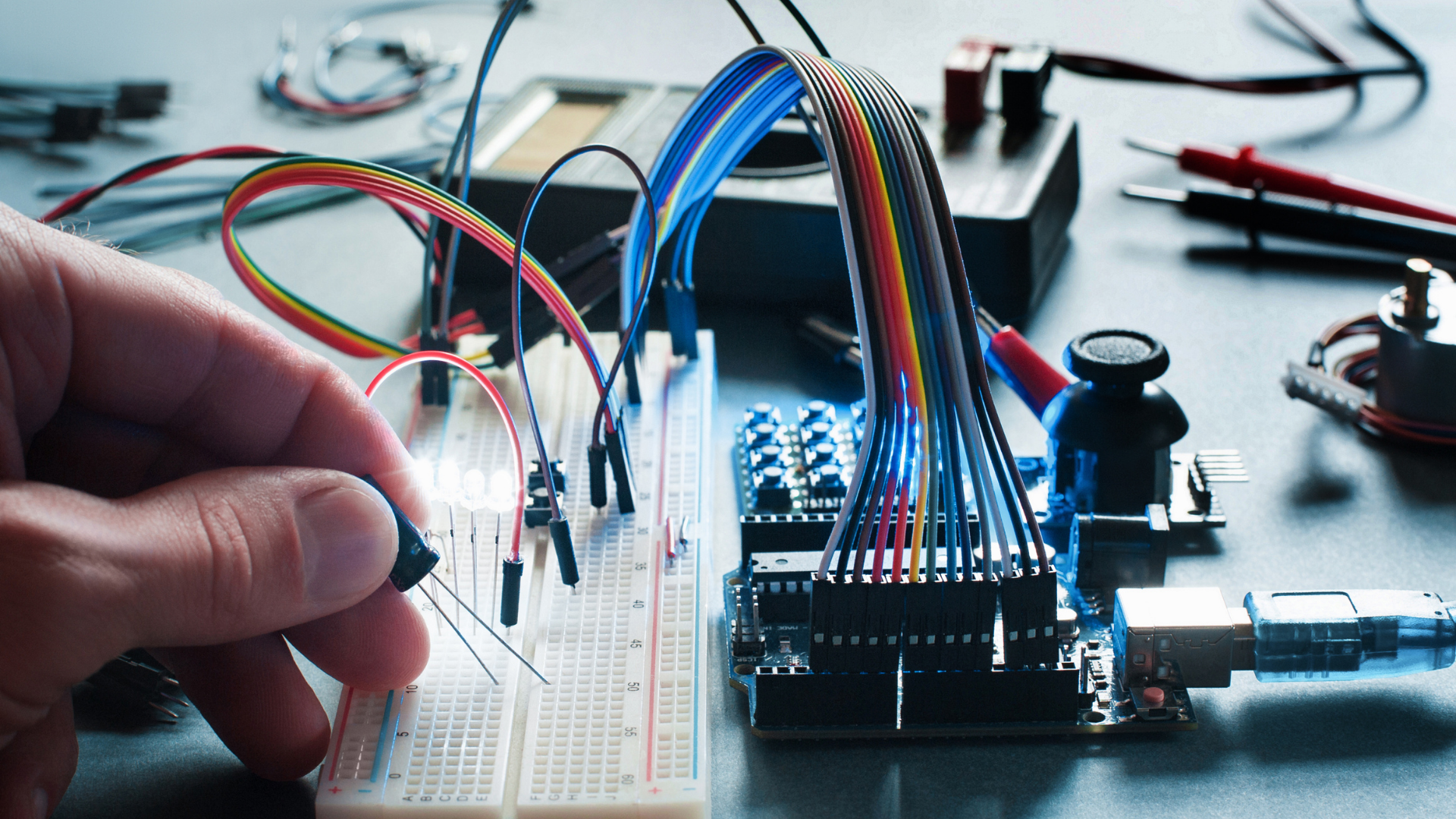 A person is working on an electronic device on a breadboard.