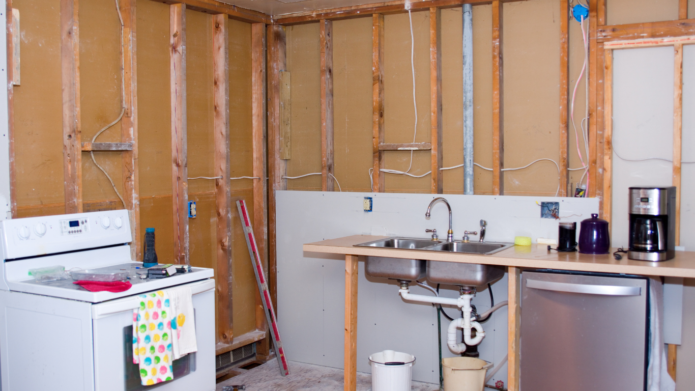 Kitchen under renovation, exposed framing, appliances present.