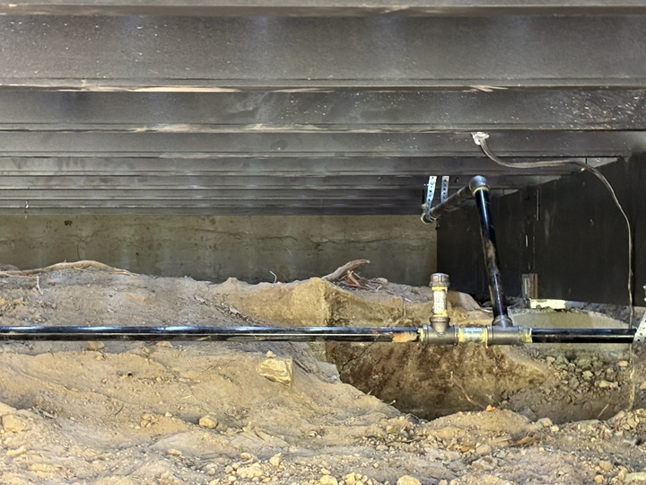 Hands using pliers on gas valve connection.