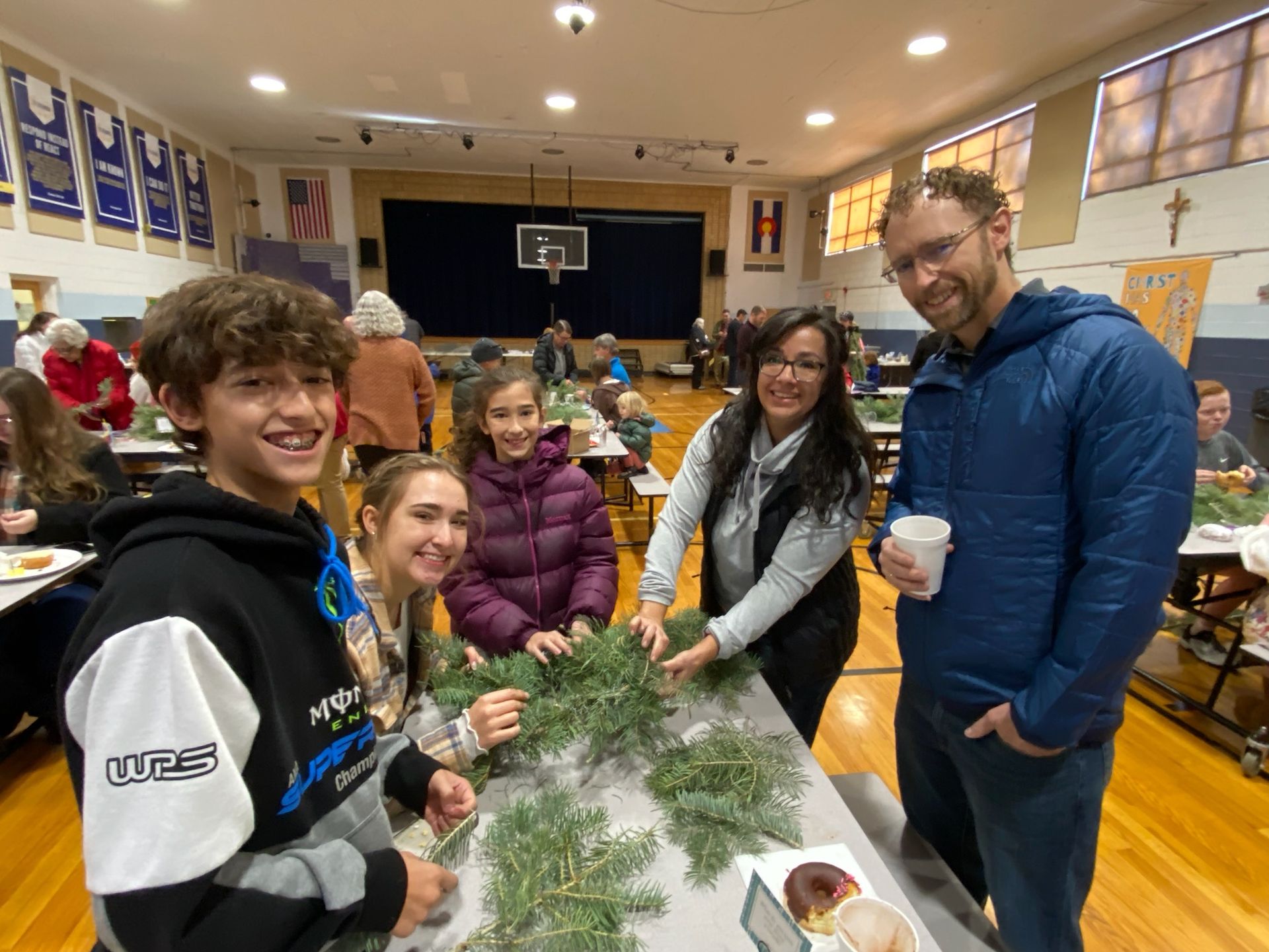 A group of children are dancing in a room with their arms in the air.