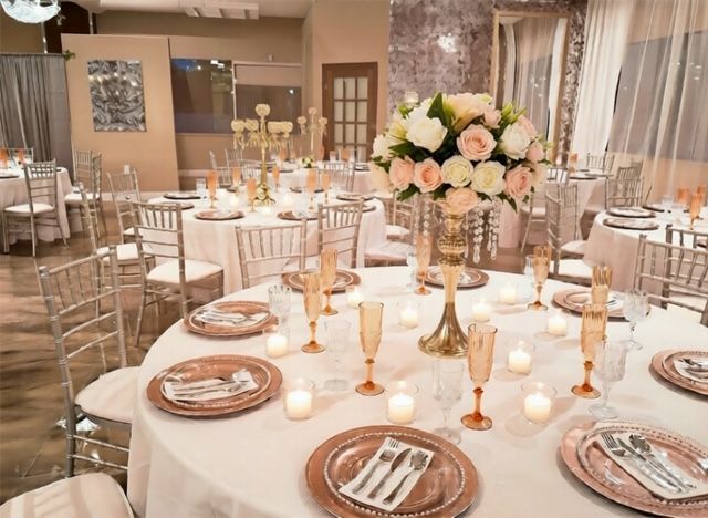 Elegant round tables set for a formal event, featuring flower centerpieces and place settings.