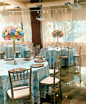 Wedding reception hall decorated with blue and white flowers and chandeliers. Tables set. Wedding reception hall decorated with blue and white flowers and chandeliers. Tables set.