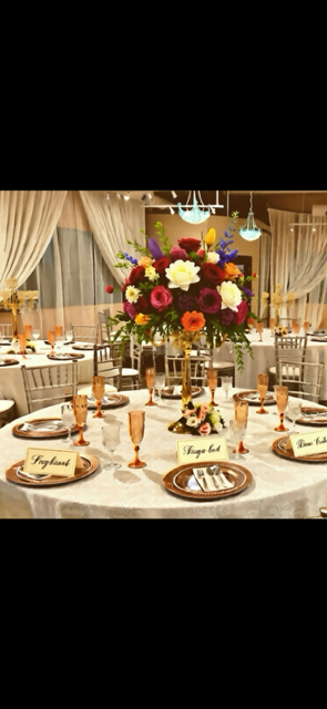 A decorated dining table with floral centerpiece, place settings, and champagne glasses.