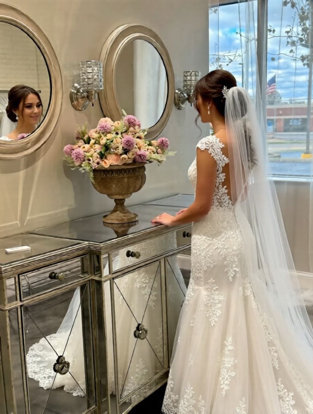Bride in a white lace dress with veil, looking at herself in a mirror in a bridal shop. Bride in a white lace dress with veil, looking at herself in a mirror in a bridal shop.