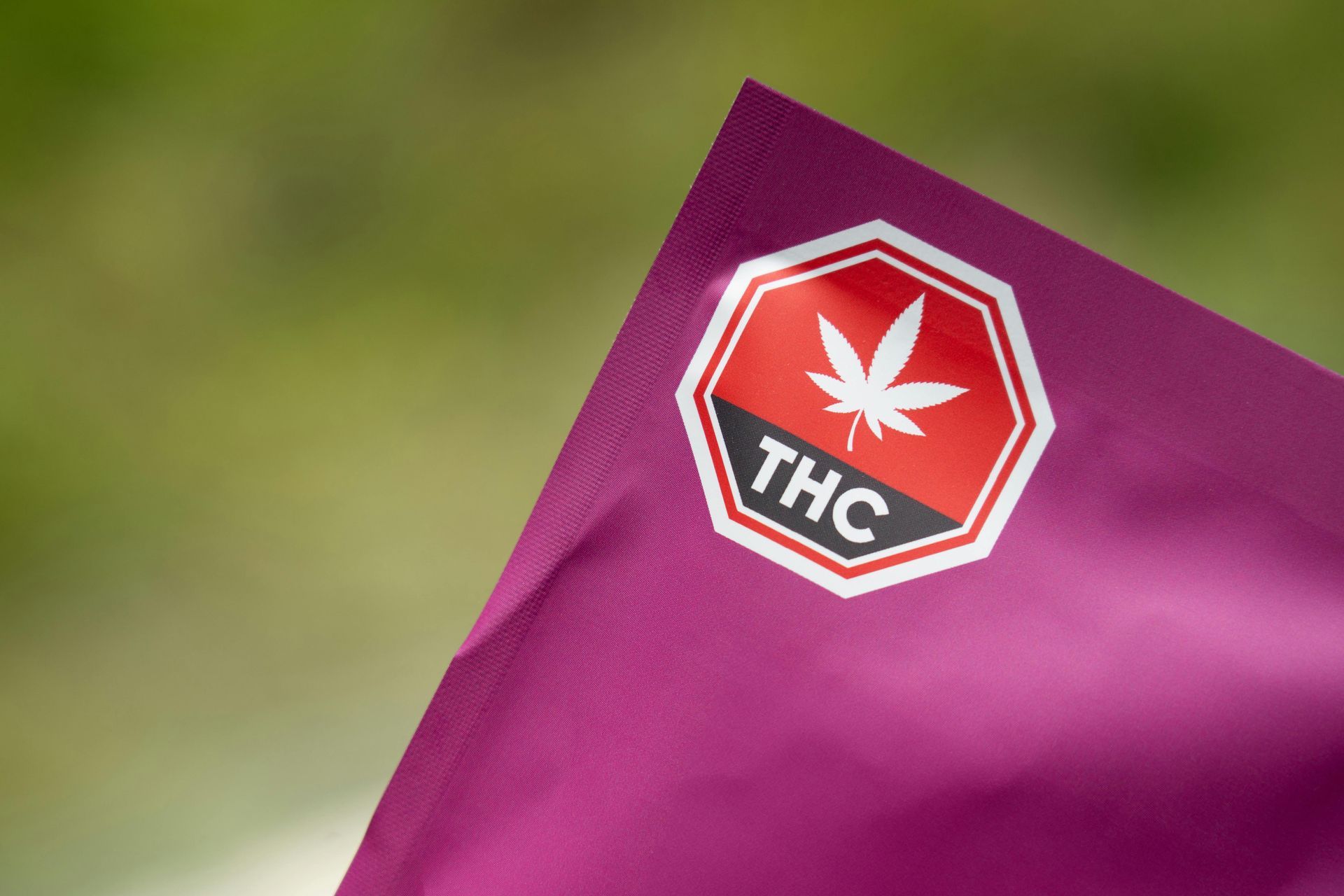Purple bag with a THC warning label and a marijuana leaf symbol.