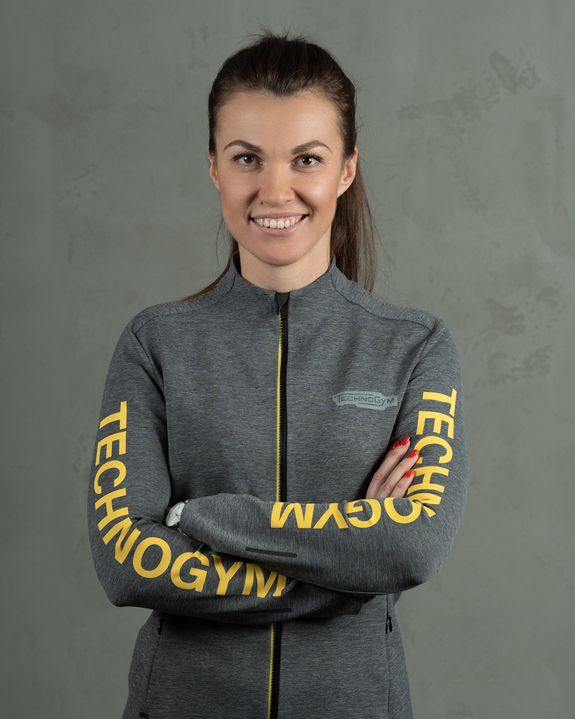 a woman wearing a jacket that says technogym on the sleeves