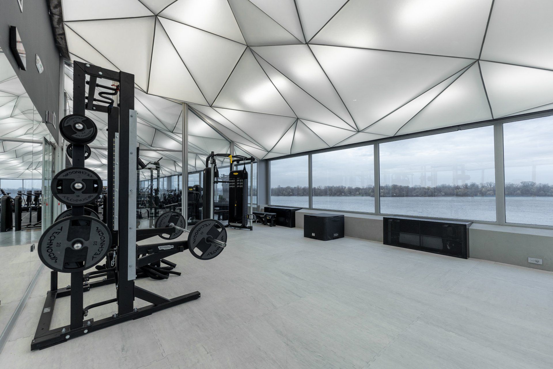 a gym with a lot of equipment and a large window