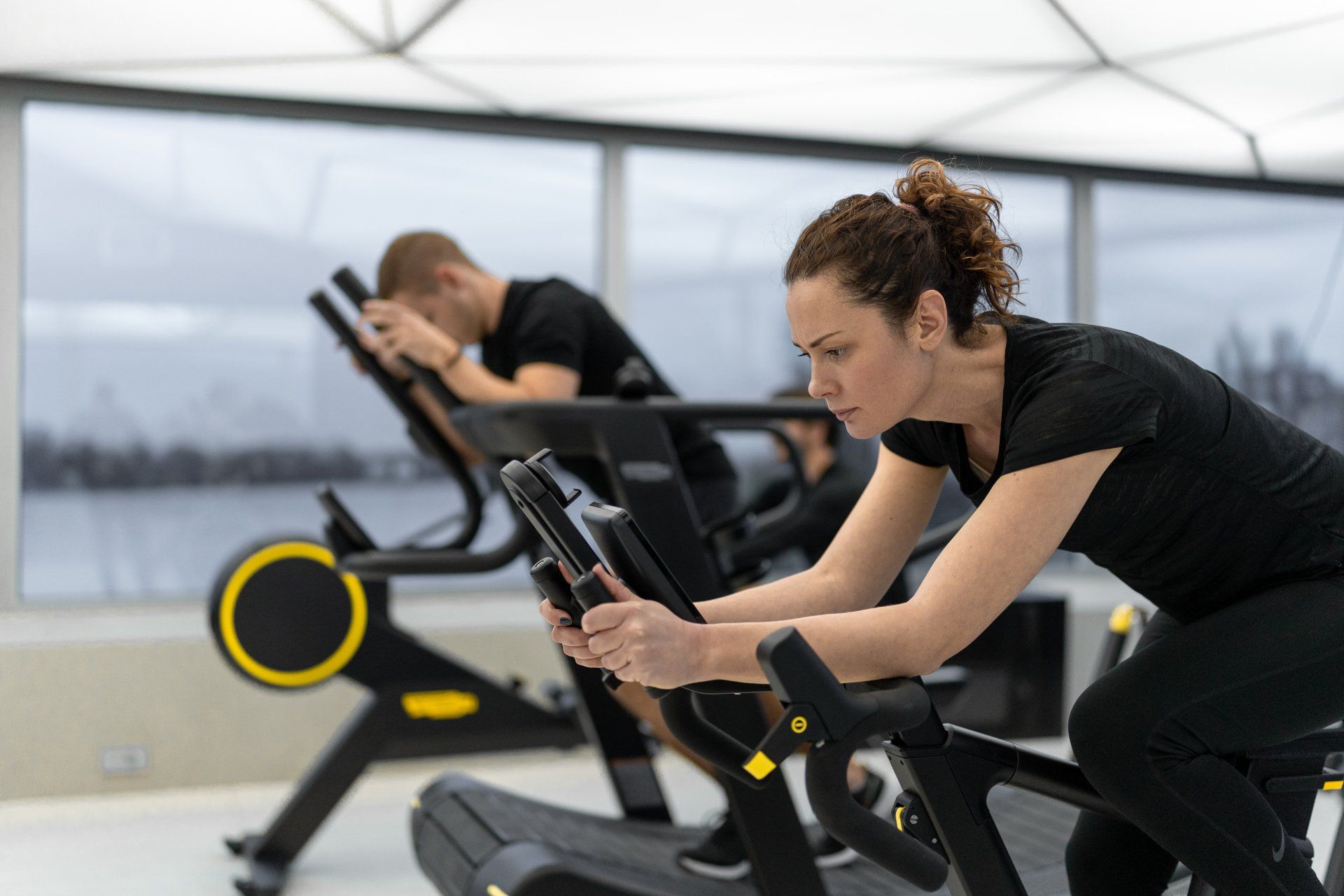 a woman is riding an exercise bike in a gym .