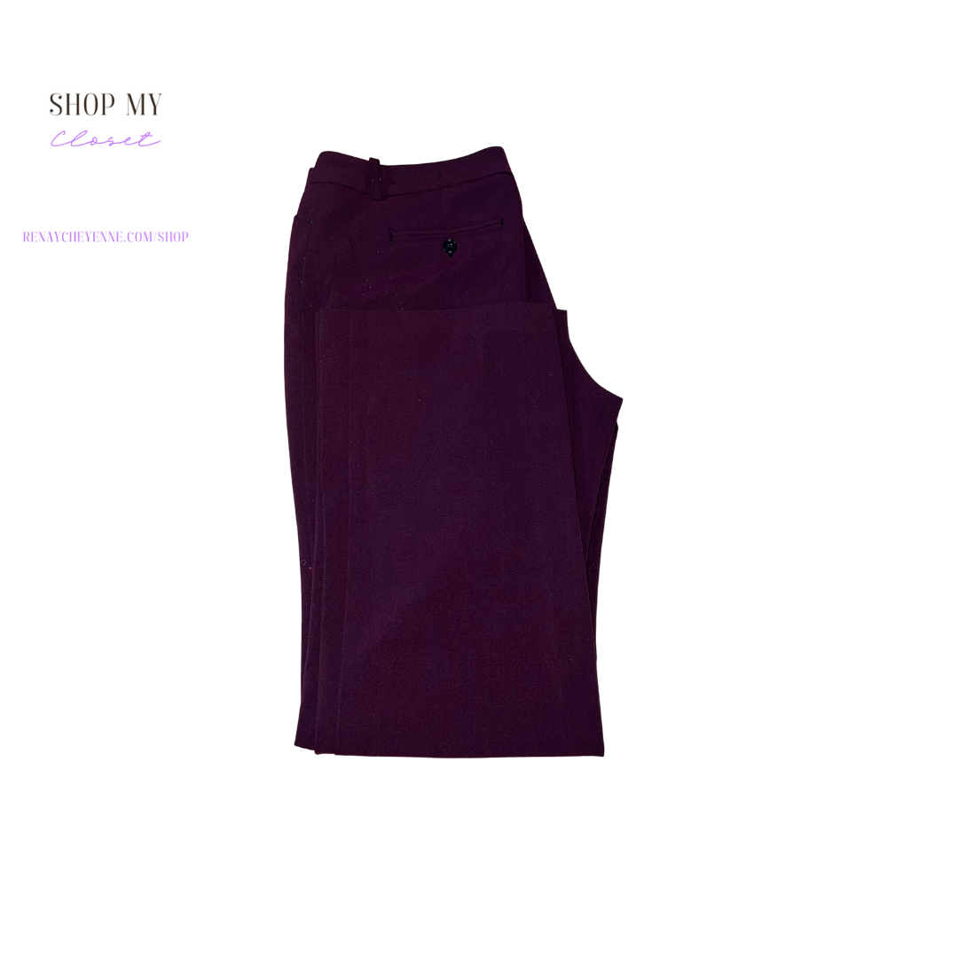 A close-up of a pair of Worthington burgundy dress pants. The pants are made of a smooth, shiny fabric and have a straight leg. They are size 12 and are on a hanger. The pants are a deep burgundy color and have a small, white Worthington logo on the front pocket.