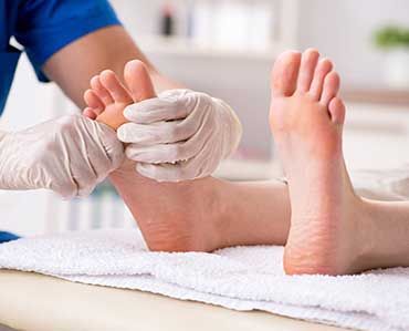 Podiatrist treating feet during procedure
