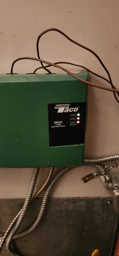 Green Taco HVAC control box with indicator lights. Wires and conduit attached.