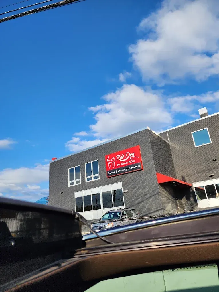 A red sign on a gray building with the words 