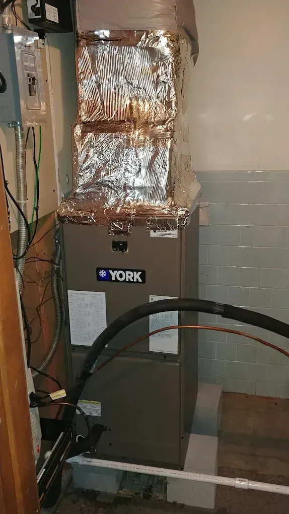 A York furnace with insulated ductwork in a basement setting.