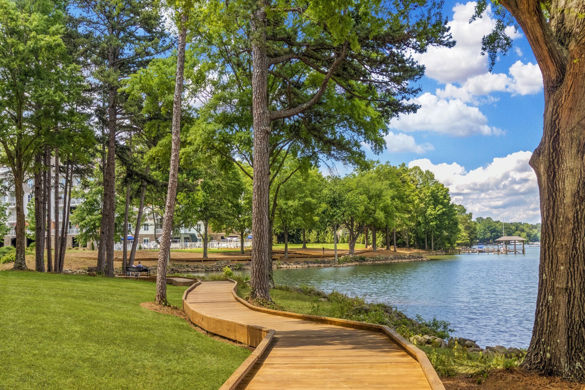 A wooden walkway leading to a lake surrounded by trees.