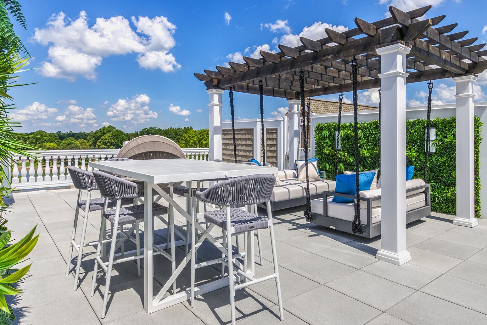 A patio with a table and chairs under a pergola at The Osprey in Mooresville, NC.