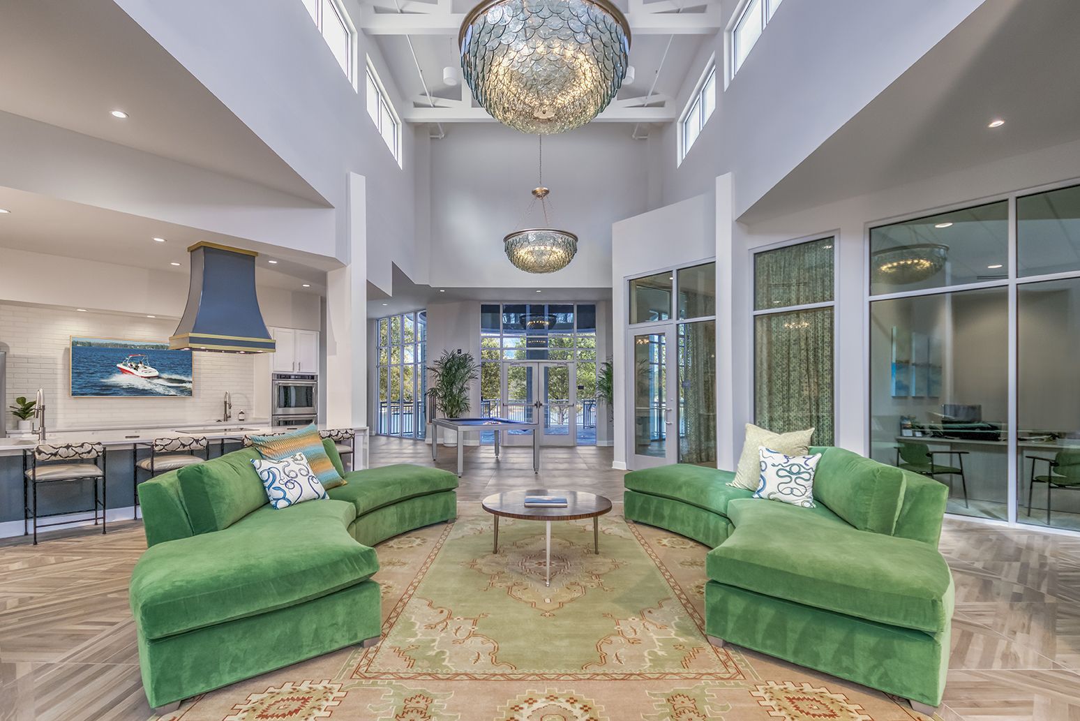 A living room filled with green furniture and a chandelier at The Osprey in Mooresville, NC.