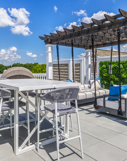 A patio with a table and chairs under a pergola at The Osprey in Mooresville, NC.