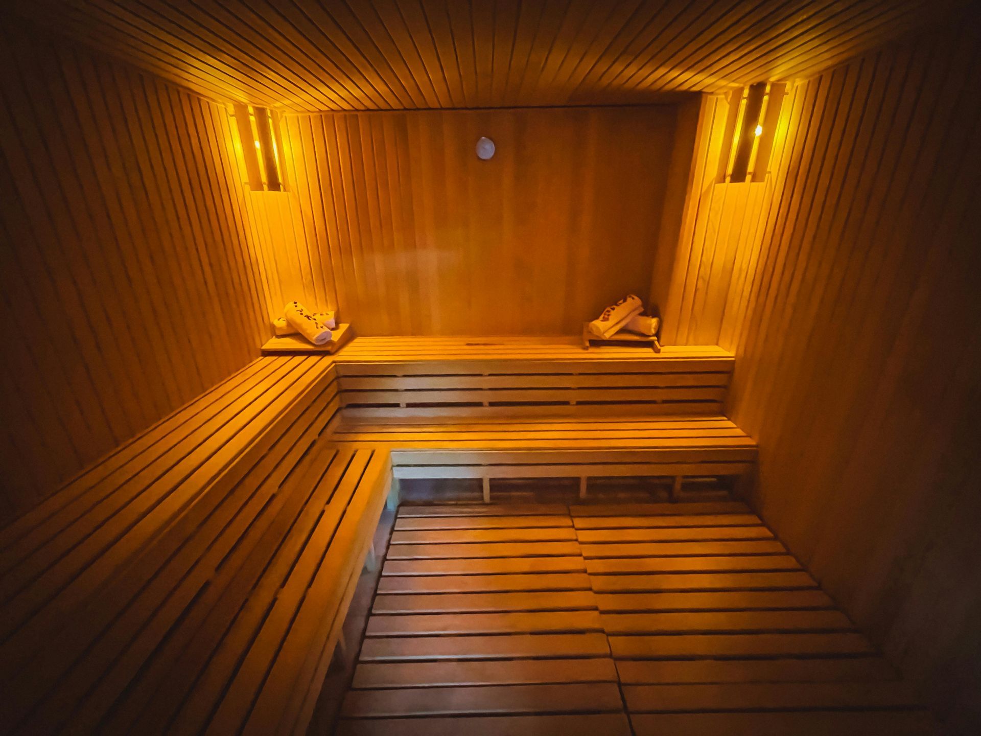 Warm wooden sauna interior with benches and amber lighting