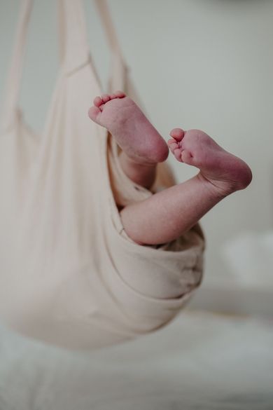 Eine Nahaufnahme der Füße eines Babys in einer Hängematte.