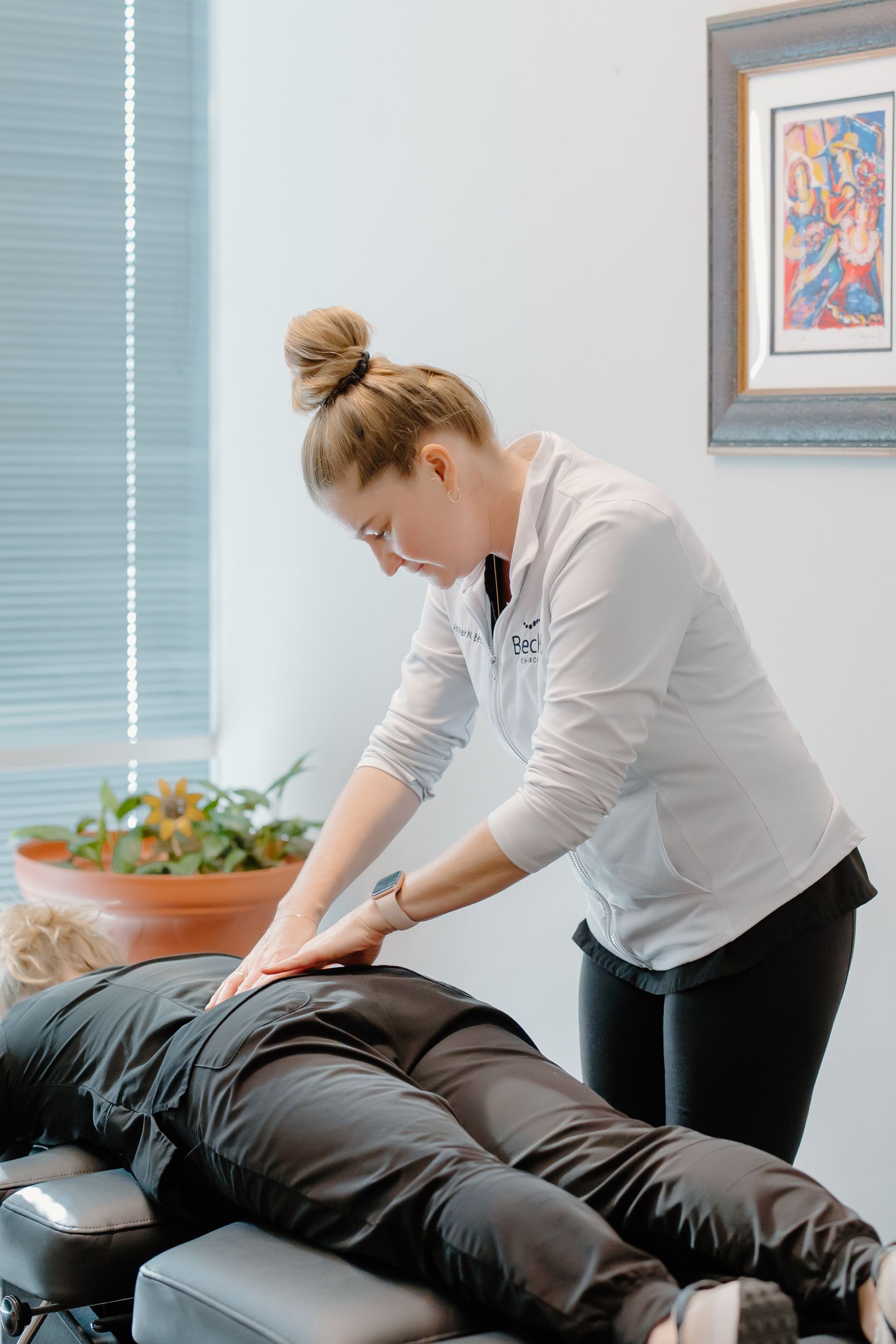A woman is giving a patient a massage on a table.