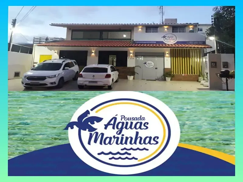 Pousada Águas Marinhas exterior. White building with cars parked out front, a sign, and water logo.