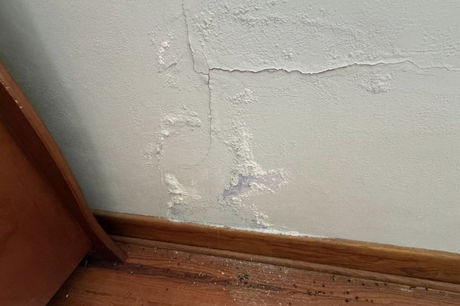 Cracked drywall and peeling paint from water damage