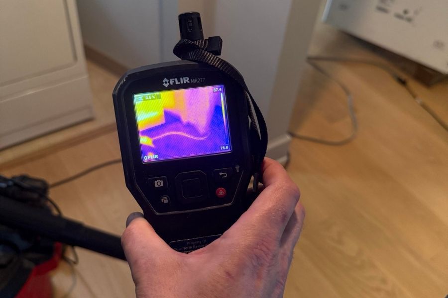 Professional moisture detector being used on wall