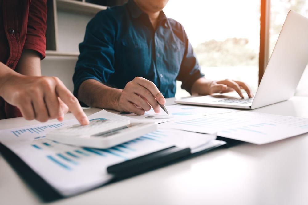 Two People Are Sitting at a Table Looking at Papers and a Laptop — SouthMac Finance In Townsville, QLD
