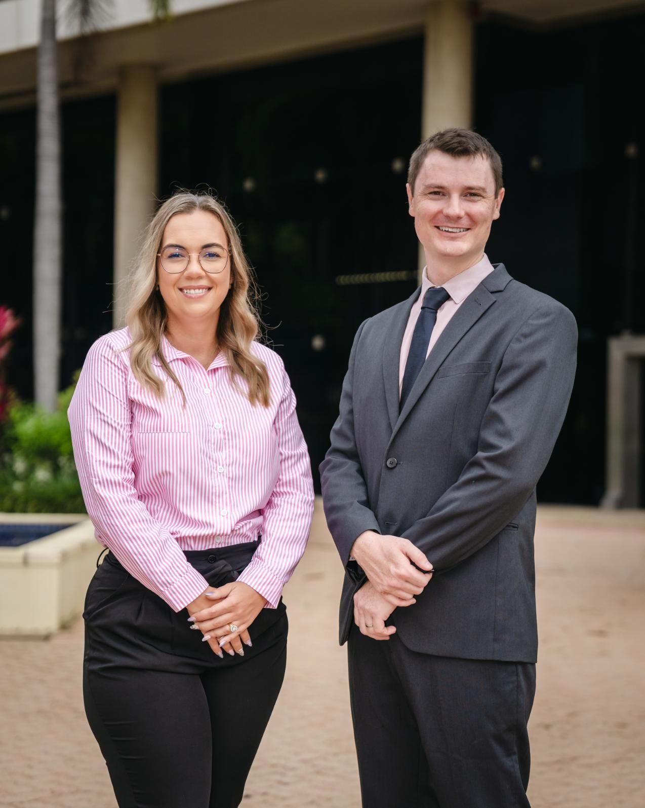 A Man and a Woman Are Standing Next to Each Other in Front of a Building — SouthMac Finance In Townsville, QLD